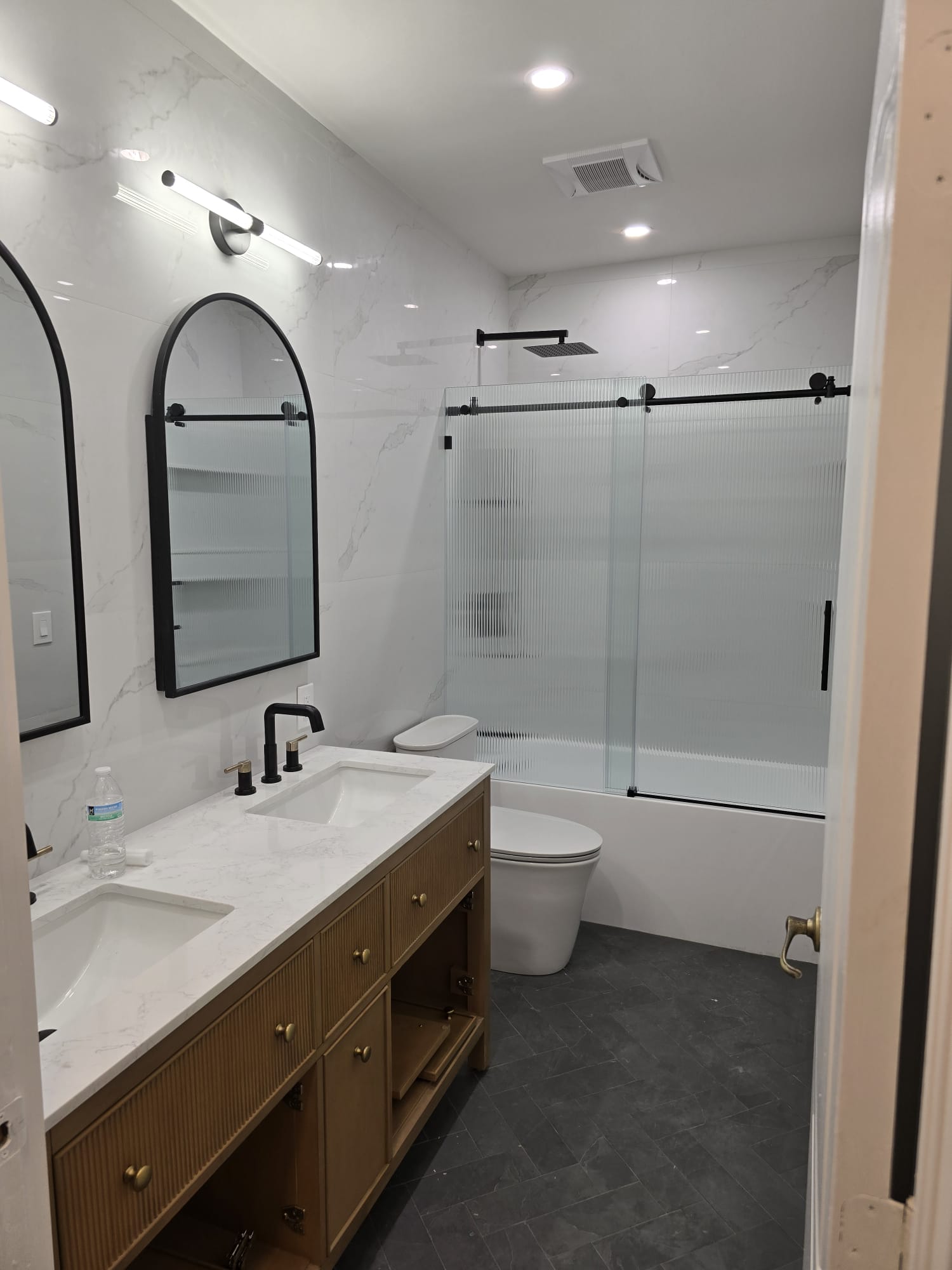 Baño con paredes de mármol blanco y doble lavamanos